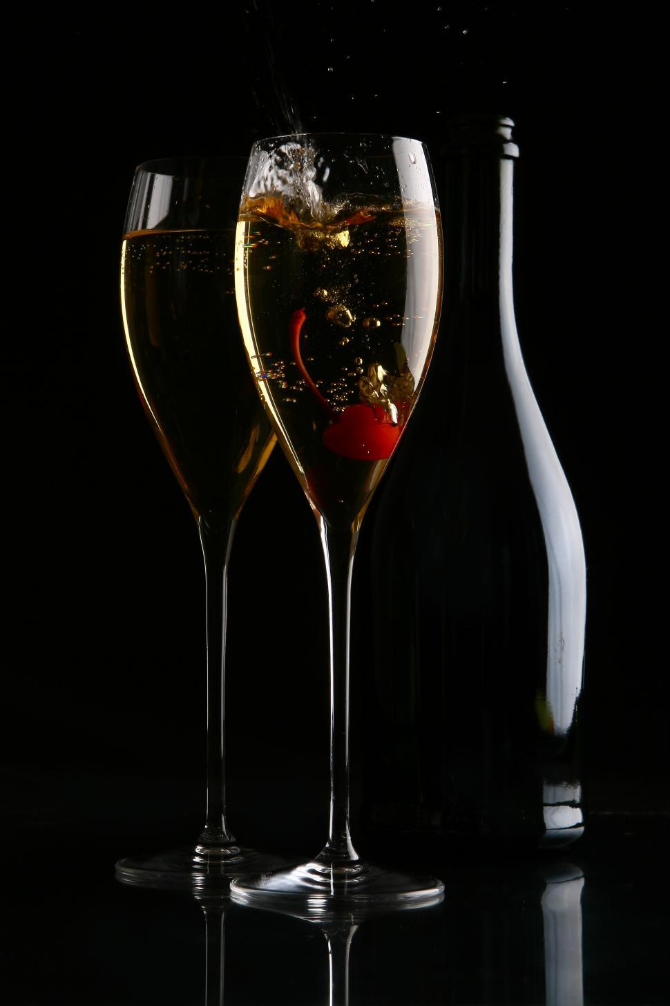 Free Image of two elegant glasses with gold champagne and cherry 