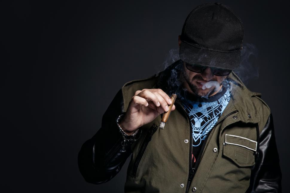 Free Image of Man in shadows smoking a cigar 