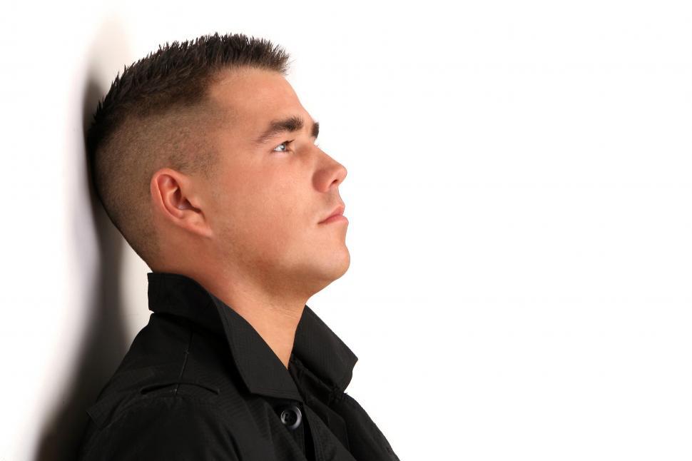 Free Image of young and attractive man leaning against a wall 