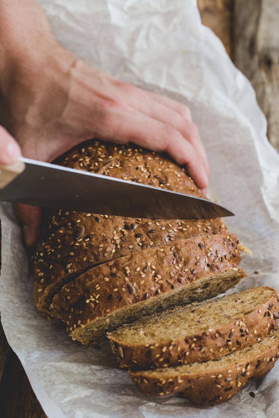 Free Image of Man slicing fresh bread 