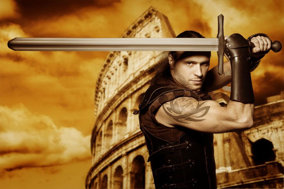 Free Image of Lone gladiator with a longsword stands in front of Colosseum 