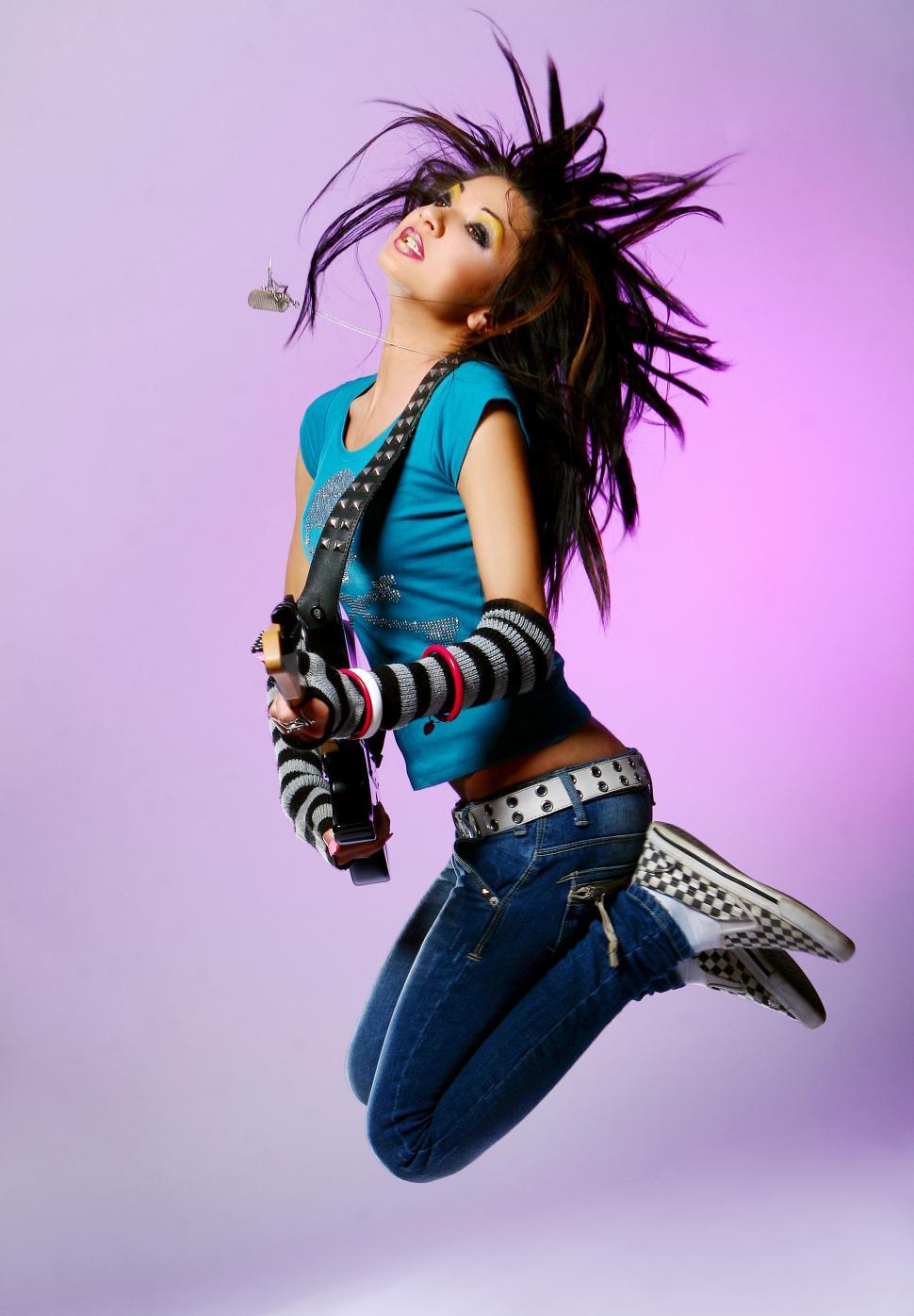 Free Image of young musician jumps with guitar 