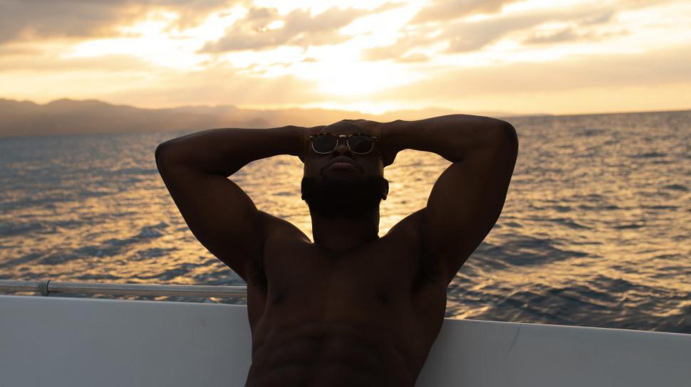 Free Image of Young Shirtless Man Relaxing on Yacht 