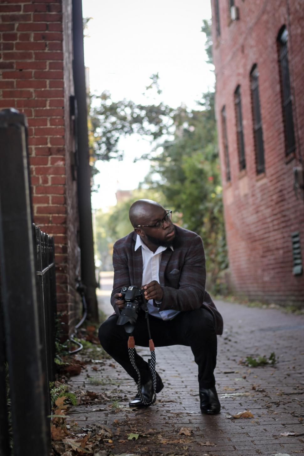 Free Image of Young Man doing street photography with SLR camera 