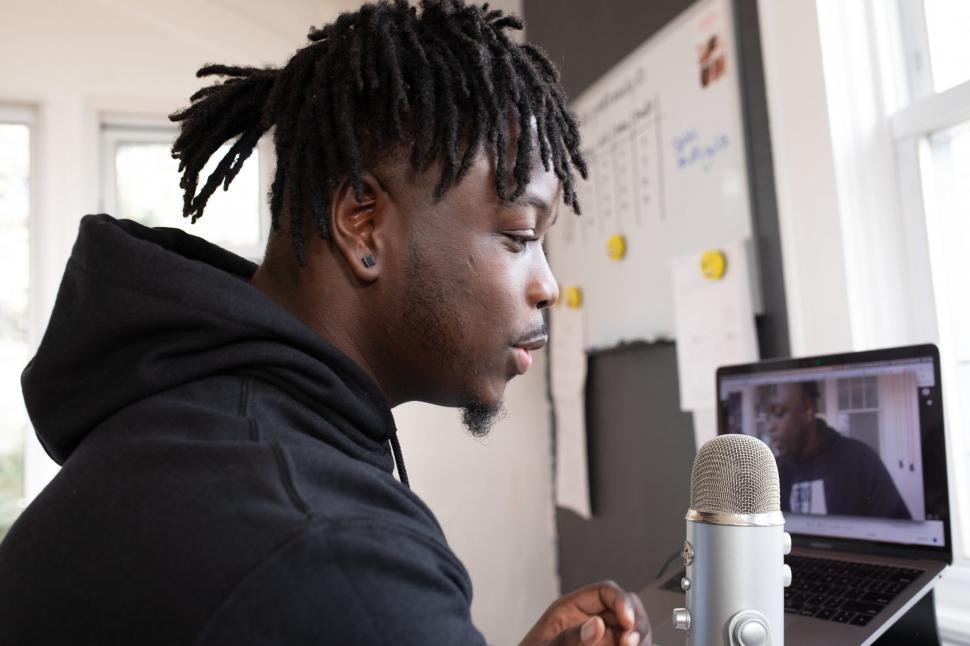 Free Image of Young Male Vlogger with mic and laptop in studio 
