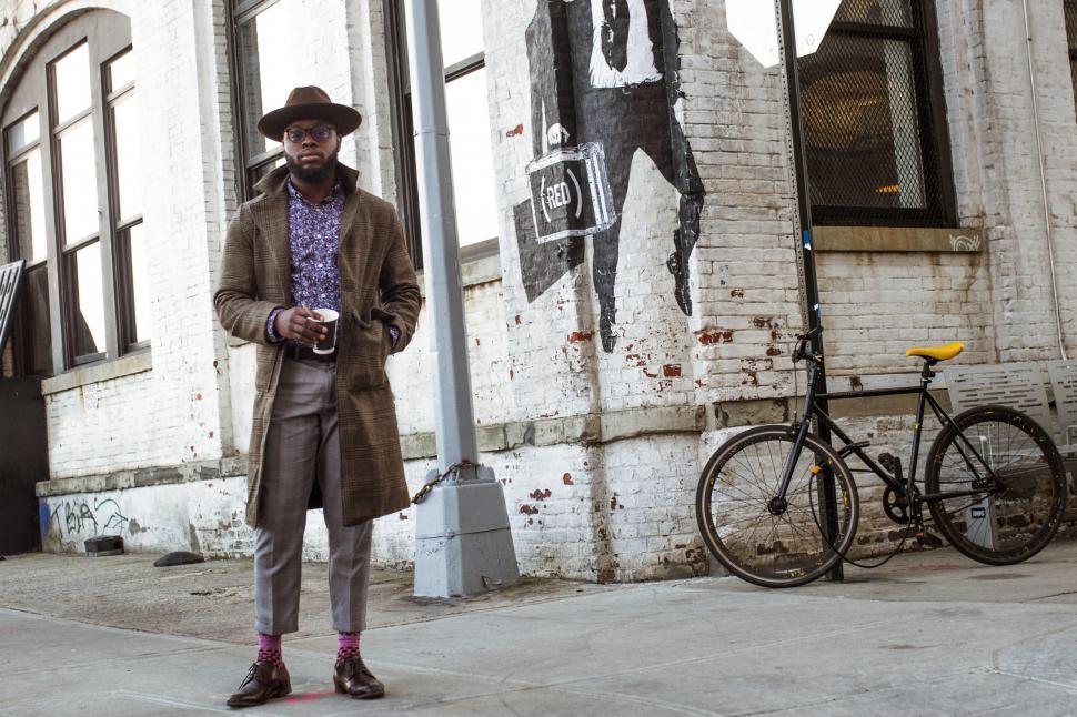 Free Image of Portrait of stylish Young Professional in tweed overcoat with coffee - looking at camera 
