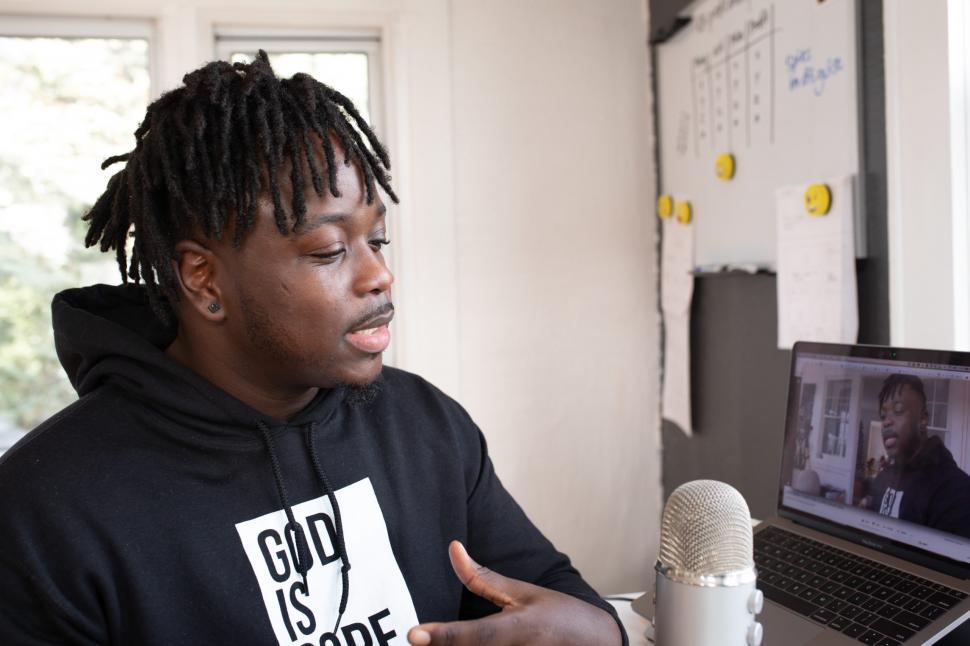 Free Image of Young Male Vlogger with mic and laptop in office 