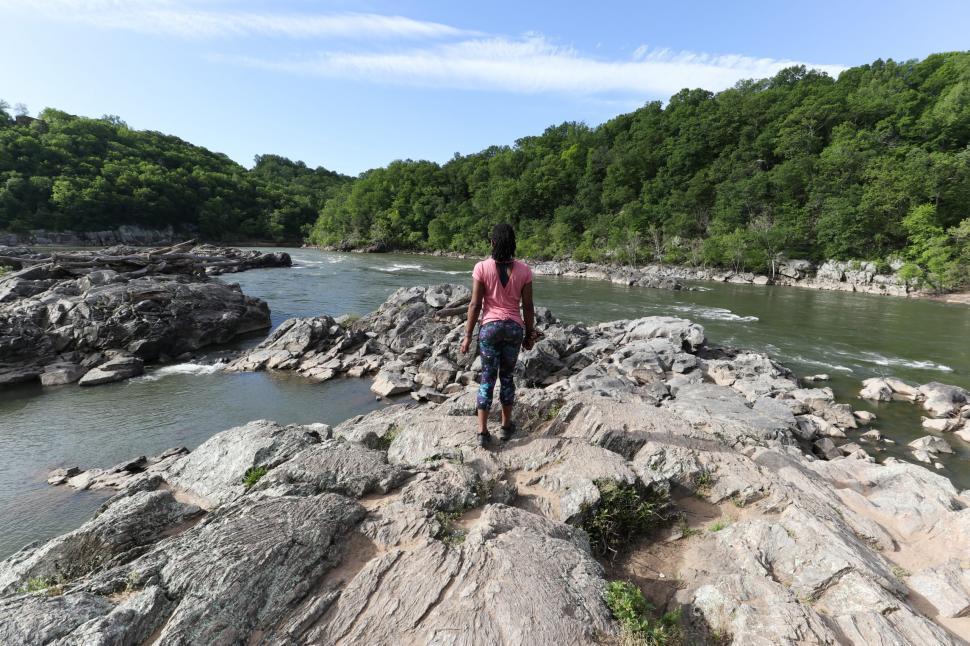 Free Image of Back View of Young Woman in yoga pants with lake and trees 