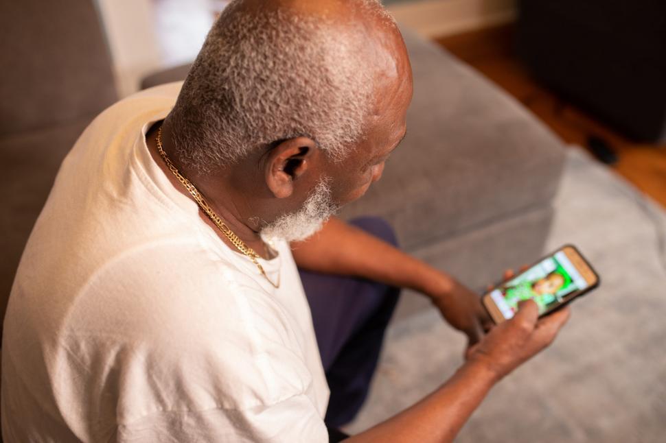 Free Image of Older Man with smart Mobile phone at home 