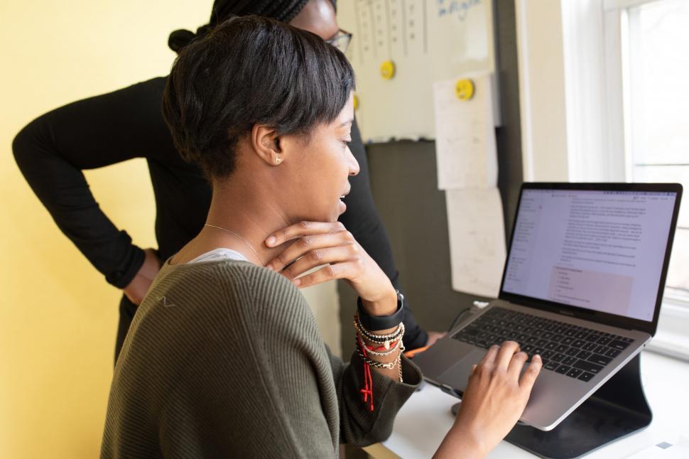 Free Image of Two Young Coworkers Working Together On Laptop 