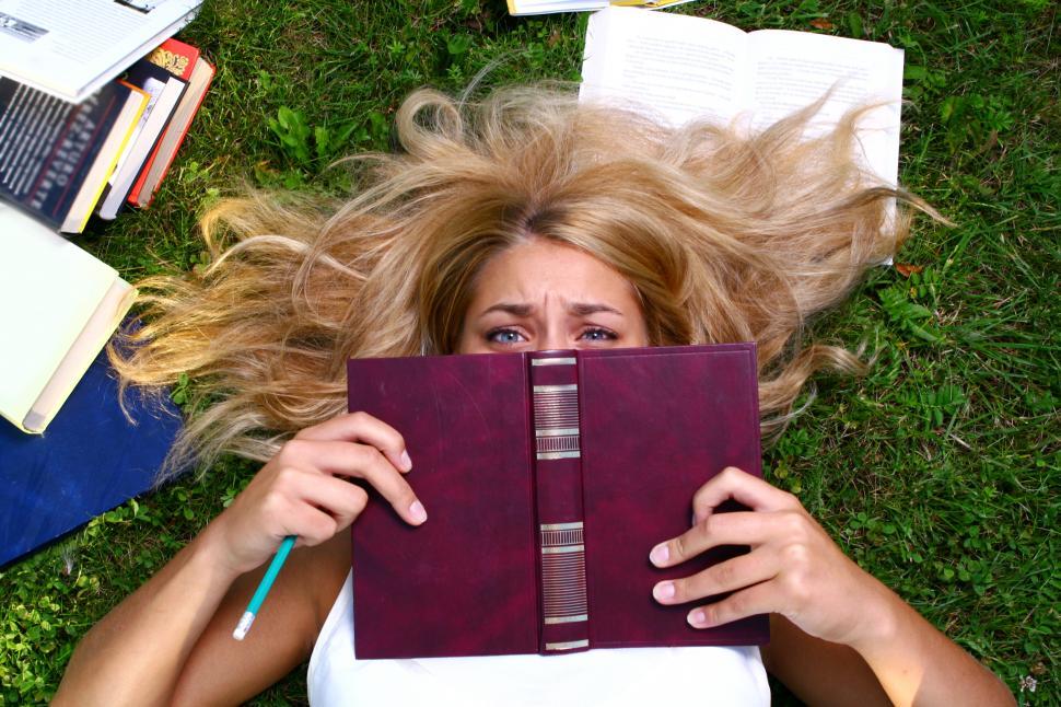 Free Image of a young student hiding from the work. Overwhelmed 
