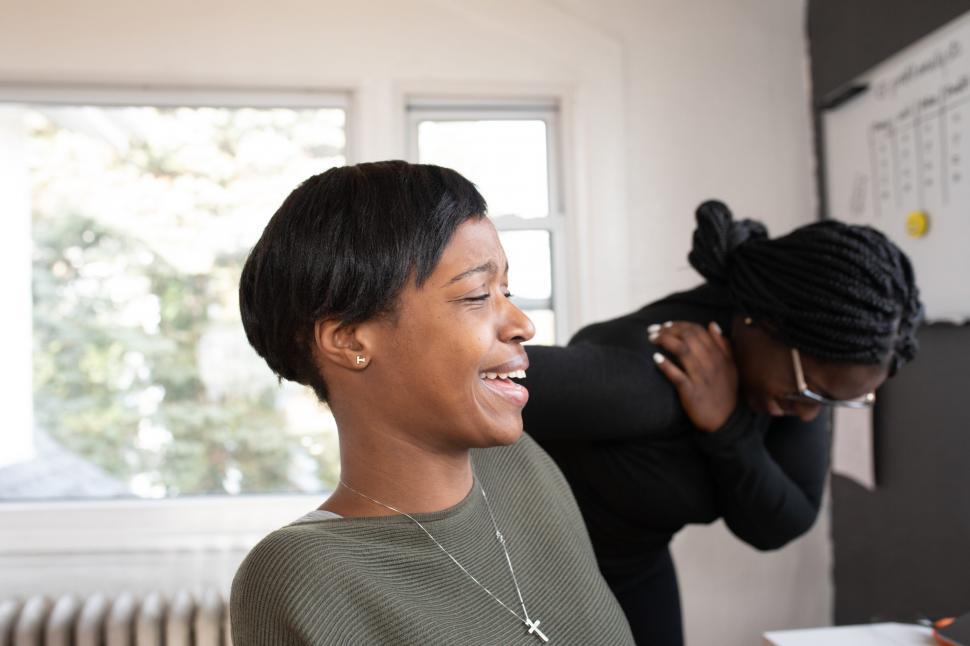 Free Image of Two Women Smiling While Working Together at workplace 