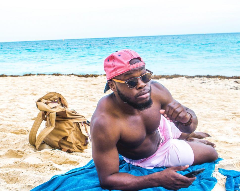 Free Image of Young Man Relaxing on Beach - looking at camera 