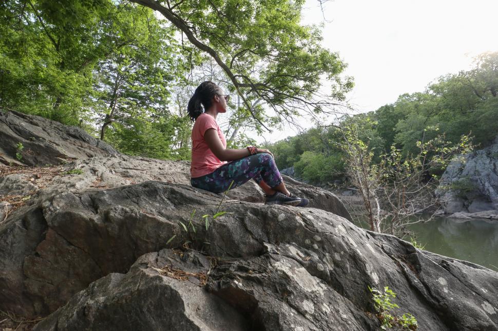 Free Image of Young Woman in pink sports t-shirt sitting under the tree near l 