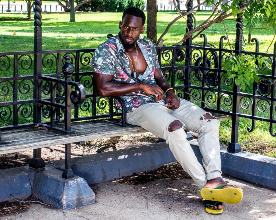 Free Image of Young Man in ripped jeans and yellow slippers 