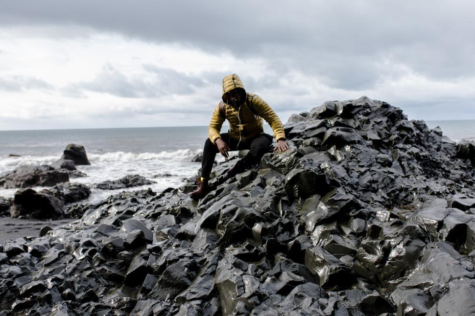 Free Image of Young Male Backpacker in Rain at seashore with cloudy sky in the 