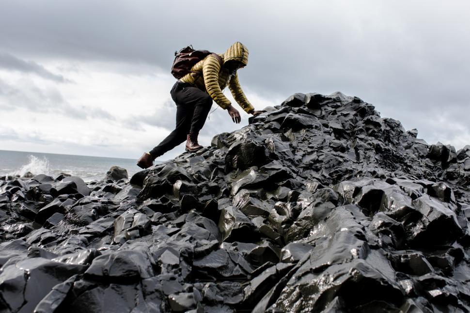 Free Image of Young Male Backpacker with leather bag on rock mountain at seash 