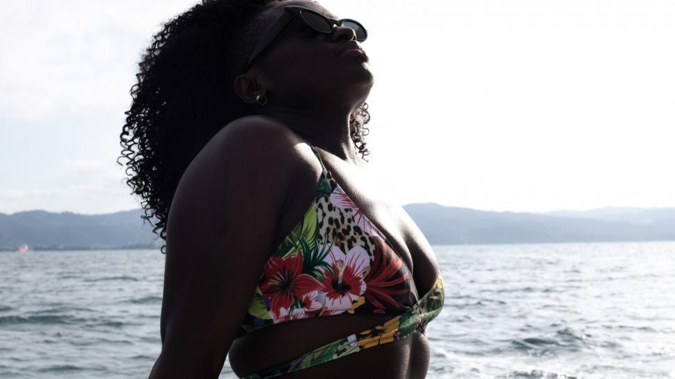 Free Image of Young Woman in Sunglasses with Curly Hair on boat - looking up 