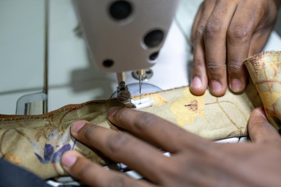 Free Image of Tailor stitching clothes on sewing machine 