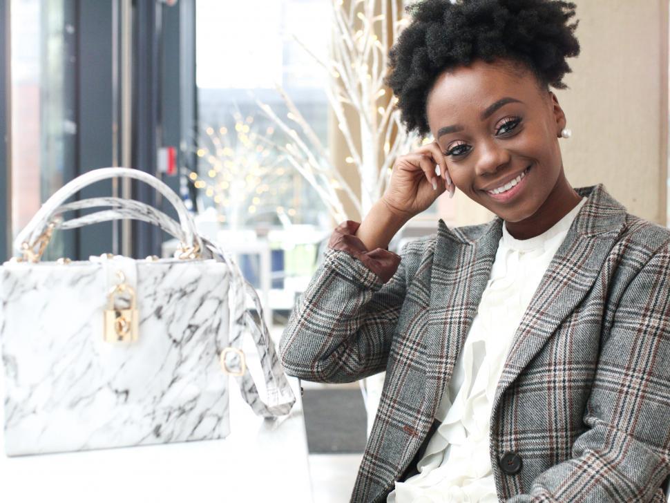 Free Image of Young business woman in tweed blazer, seated - looking at camera 