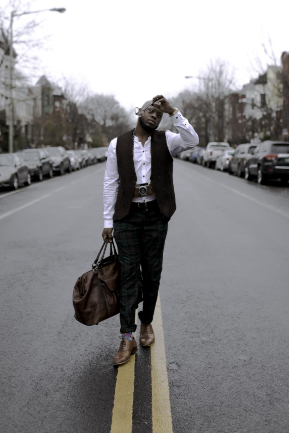 Free Image of Young Man with leather bag and vintage camera 