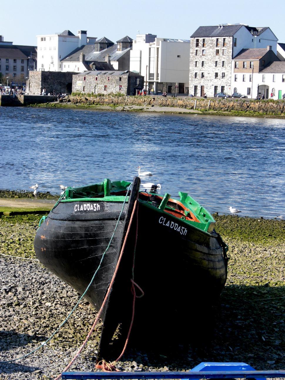 Free Image of Boat Resting on Beach Beside Water 