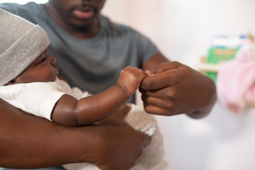Free Image of Little Baby in beanie cap holding young father hand 