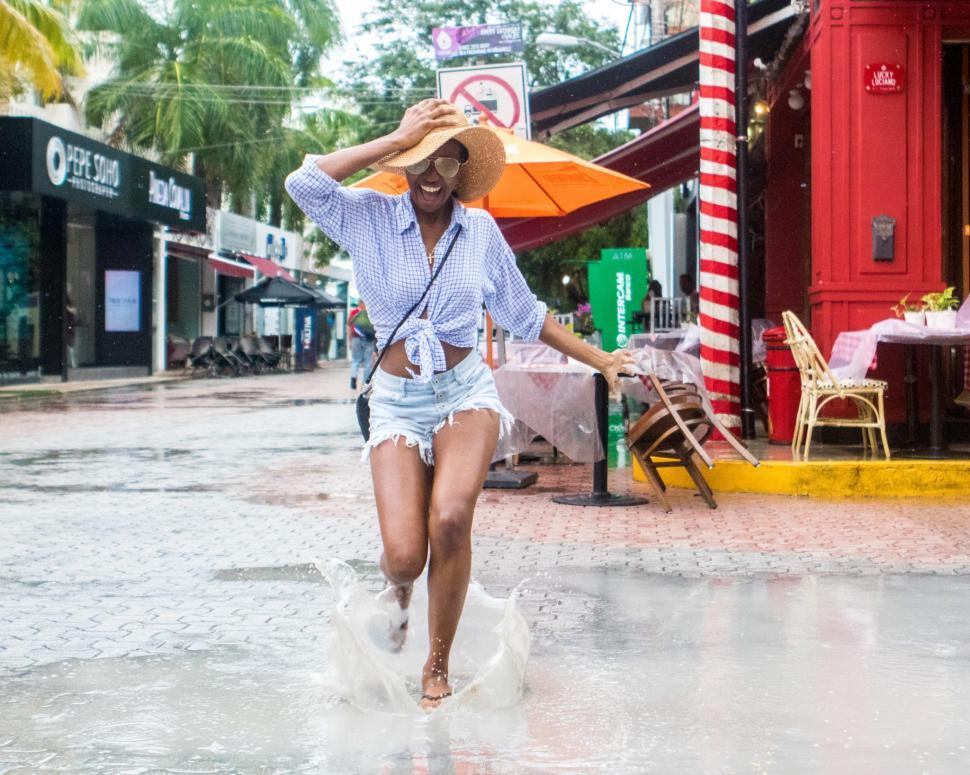 Free Image of Young Woman in Denim Shorts and sling bag in the rain 