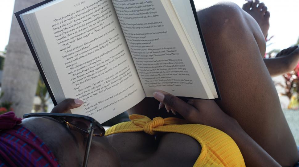Free Image of Young Woman in sunglasses with book 