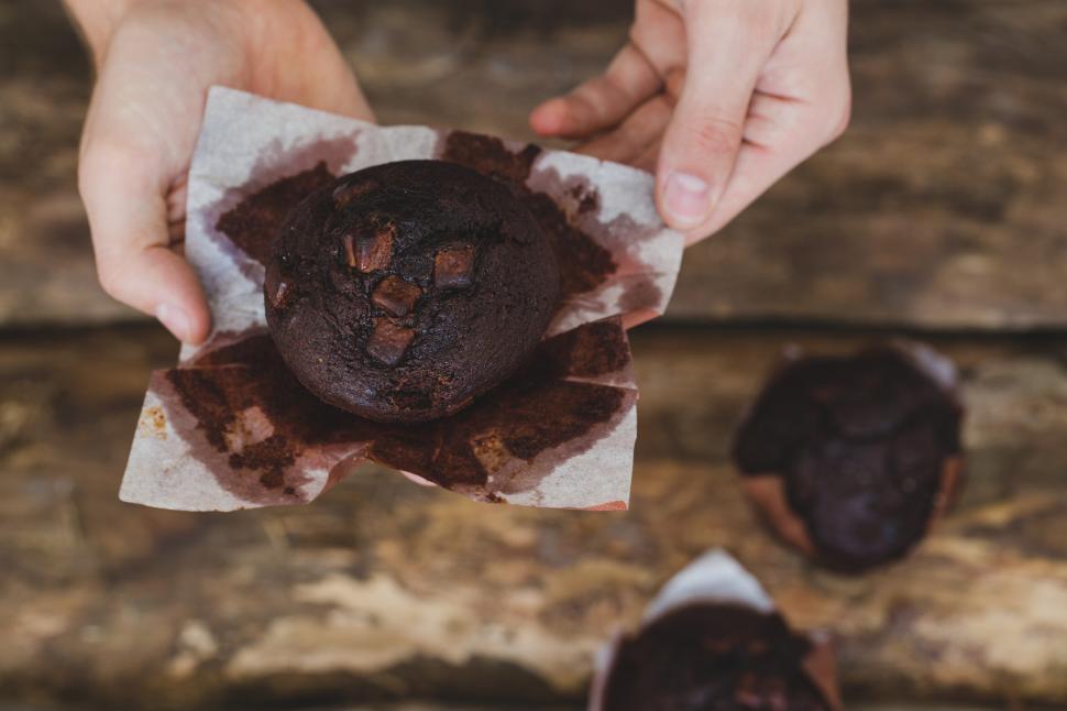 Free Image of Unwrapping a delicious muffin on the table 