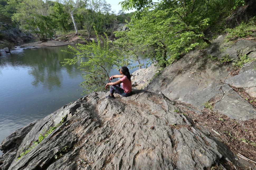Free Image of Young Woman in yoga pants sitting near lake 