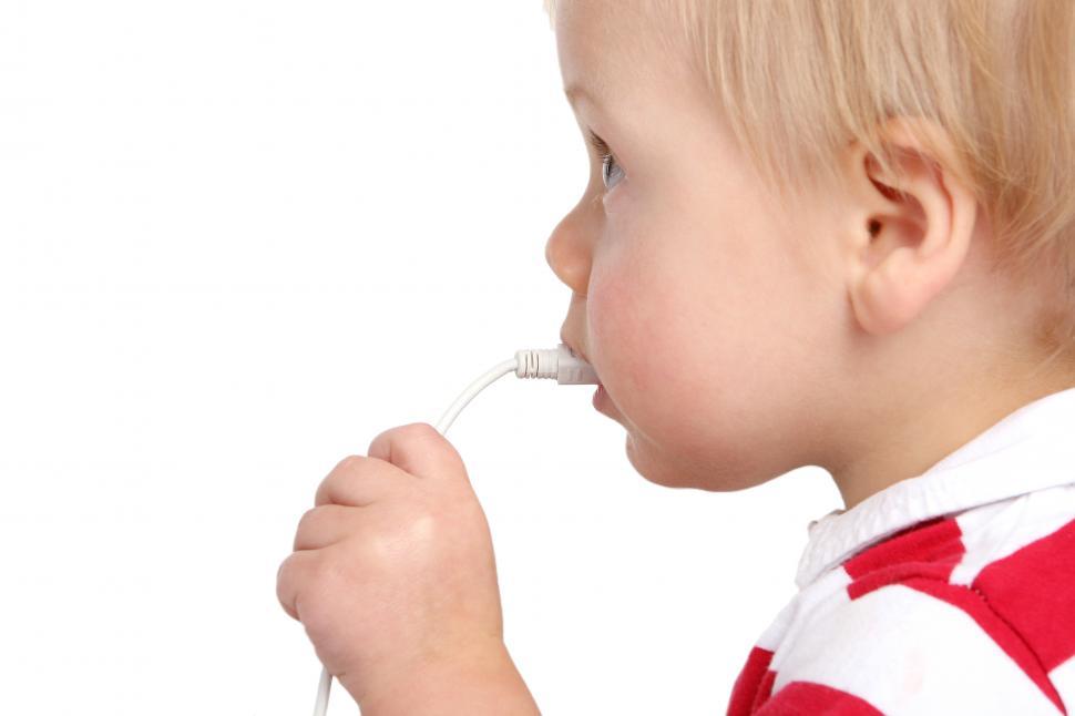 Free Image of funny kid chewing on a computer cable 