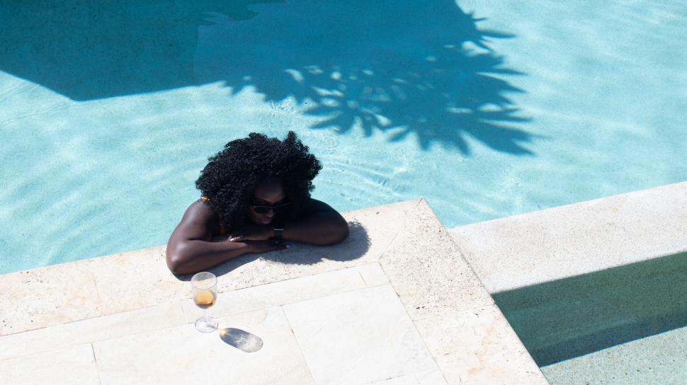 Free Image of Young Woman standing at the edge of a swimming pool 