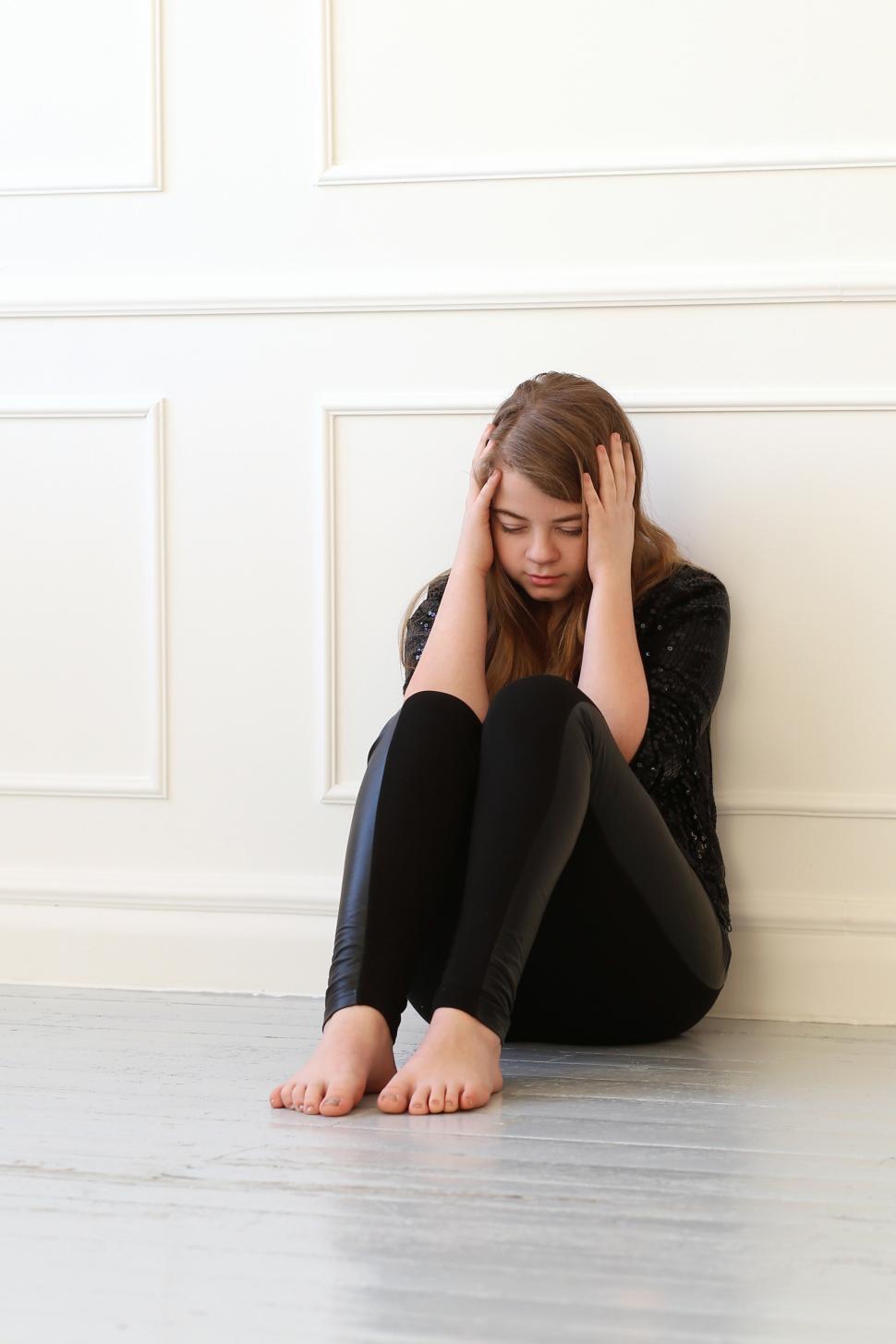 Free Image of Teenager with hands on head, sitting 