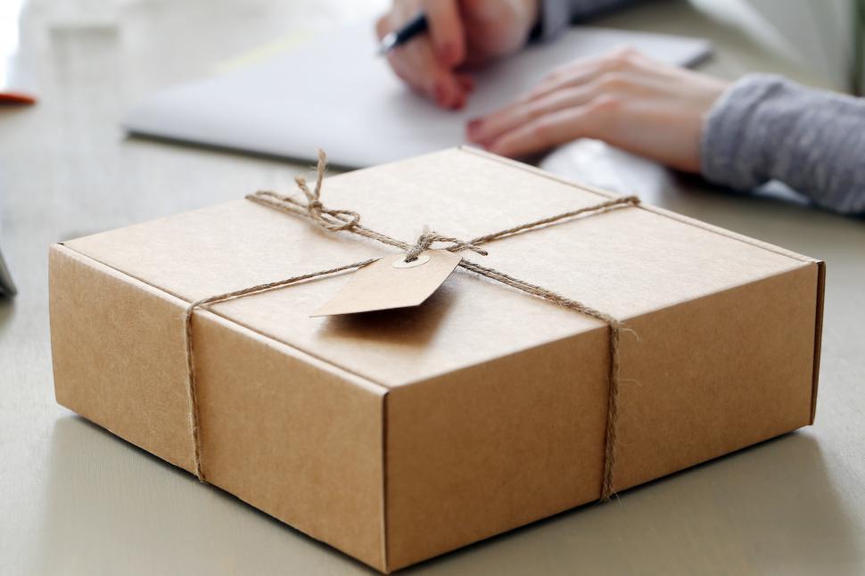 Free Image of Package with tag, wrapped in twine sitting on the table 