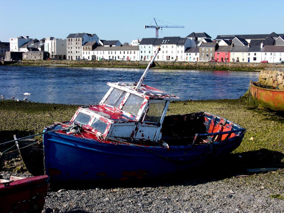 Free Image of Boat Resting on Beach Next to Water 