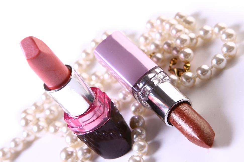 Free Image of a red lipstick with pearls on white 