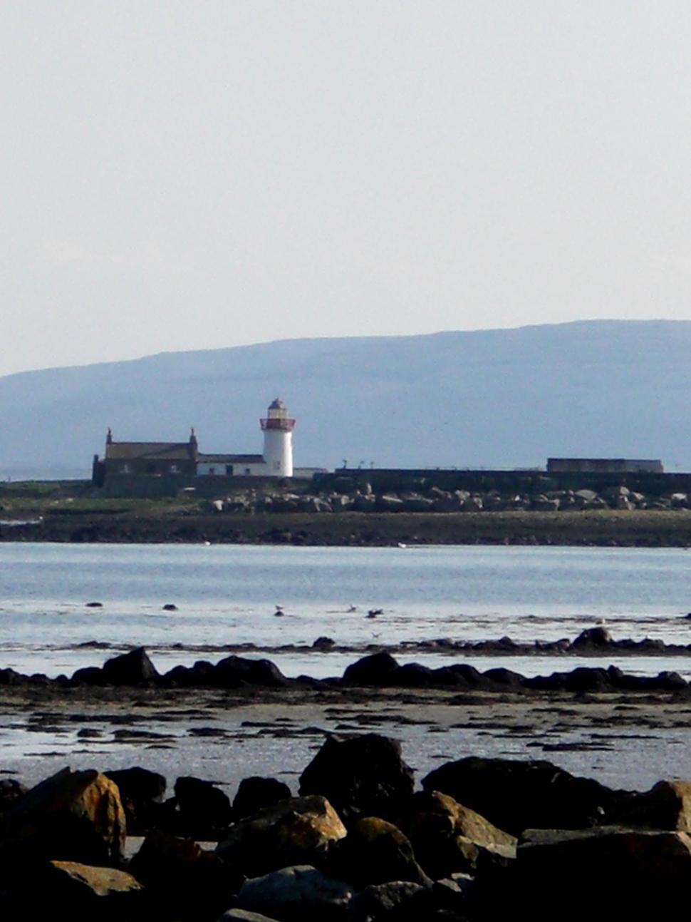 Free Image of Lighthouse on Rocky Shore Near Body of Water 