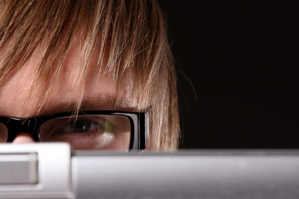 Free Image of Man in glasses peeking over screen 