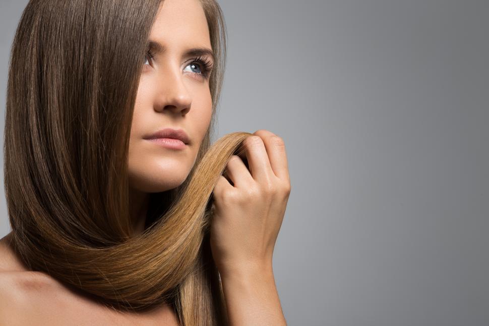 Free Image of Woman with her own hair clasped in her hand 