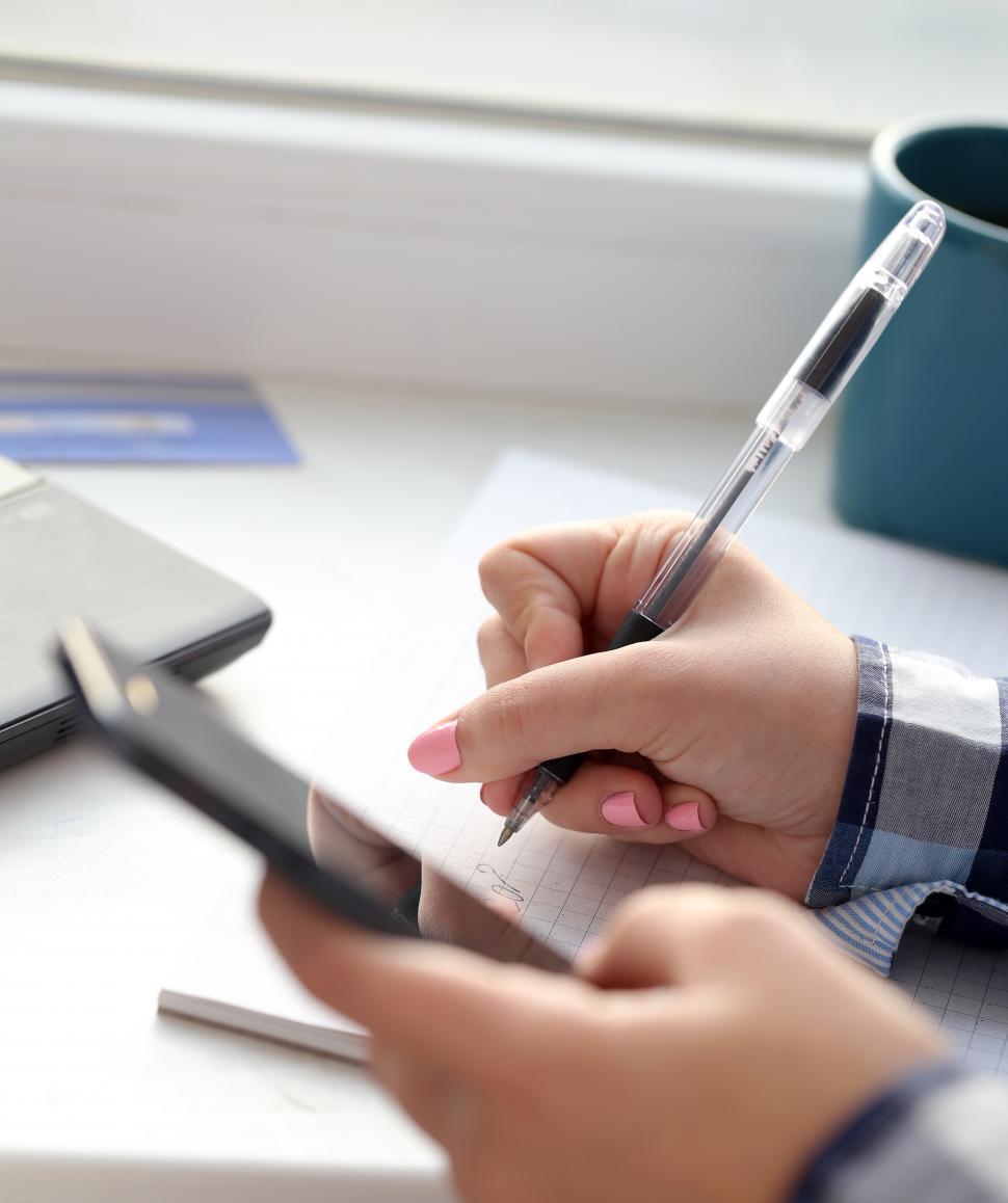 Free Image of Woman writes in notebook 
