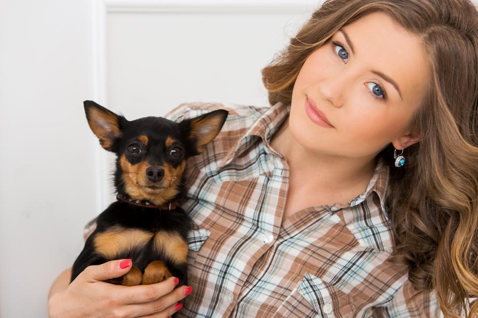 Free Image of Young woman holding a dog 