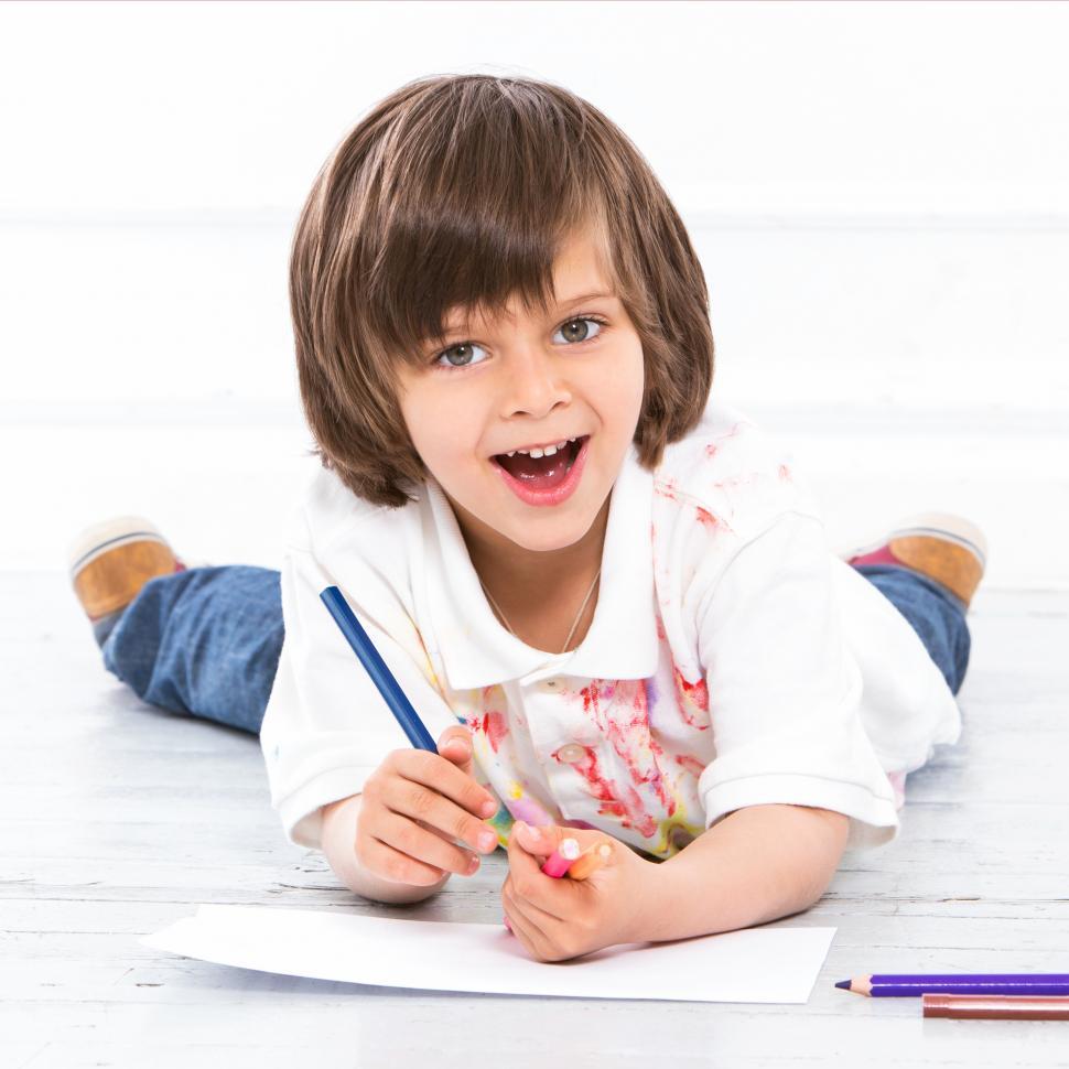 Free Image of Adorable kid on the floor coloring 