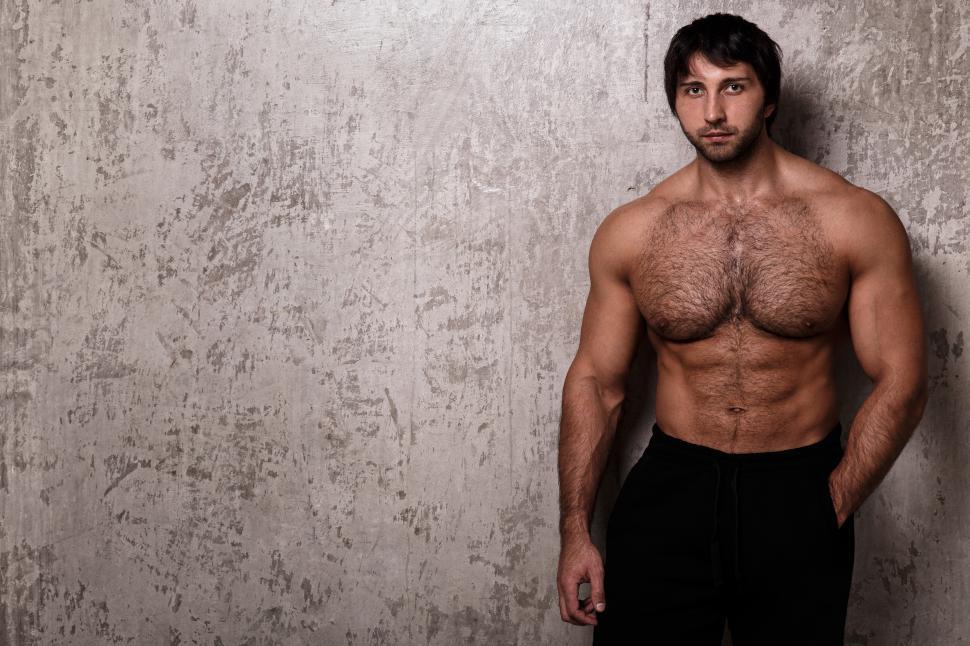 Free Image of Shirtless muscular guy against textured wall 