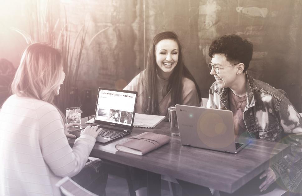 Free Image of Friends Smiling and Working with Laptops at a Cafe 