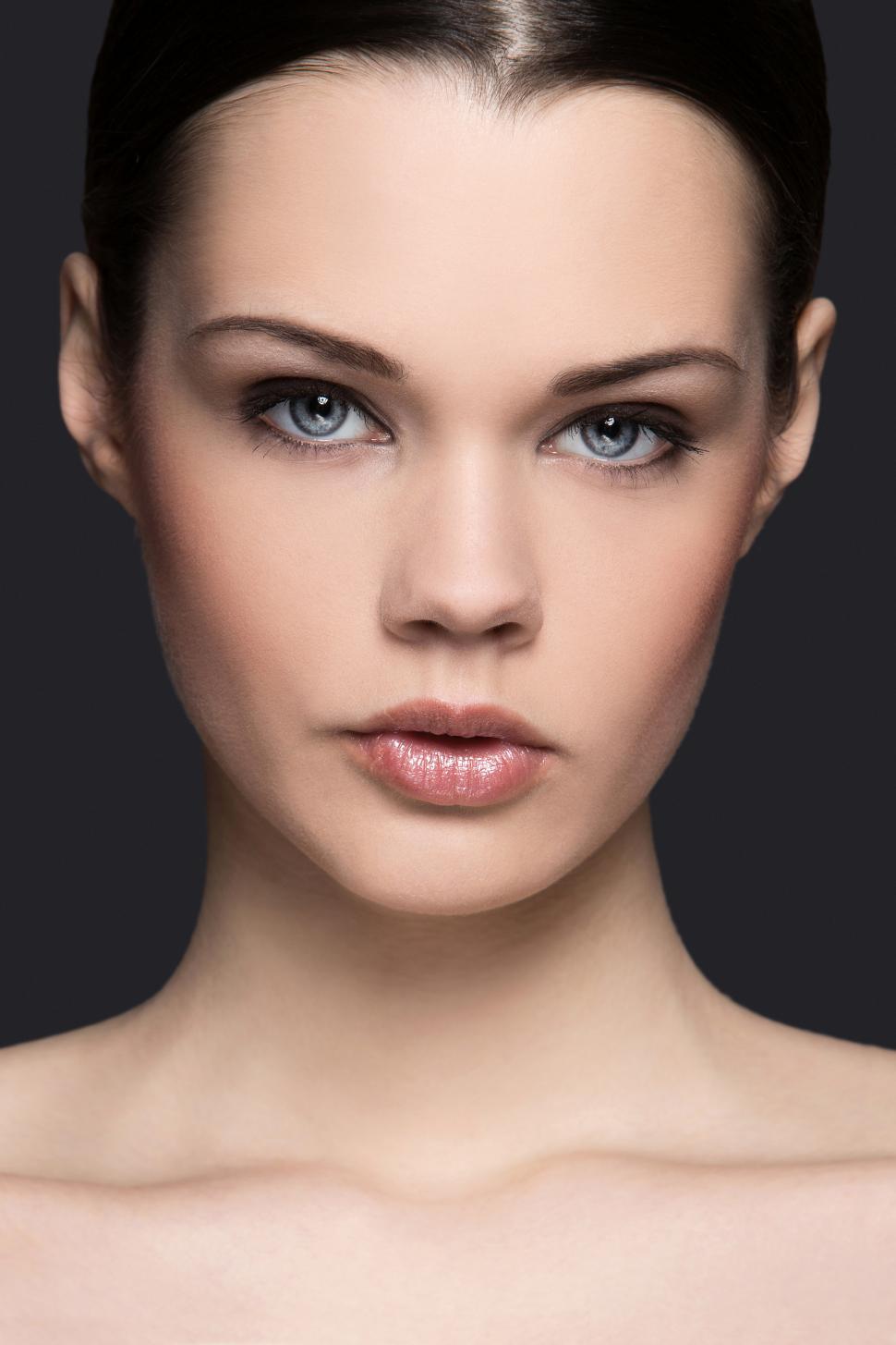 Free Image of Beautiful woman with dark hair on a gray background 