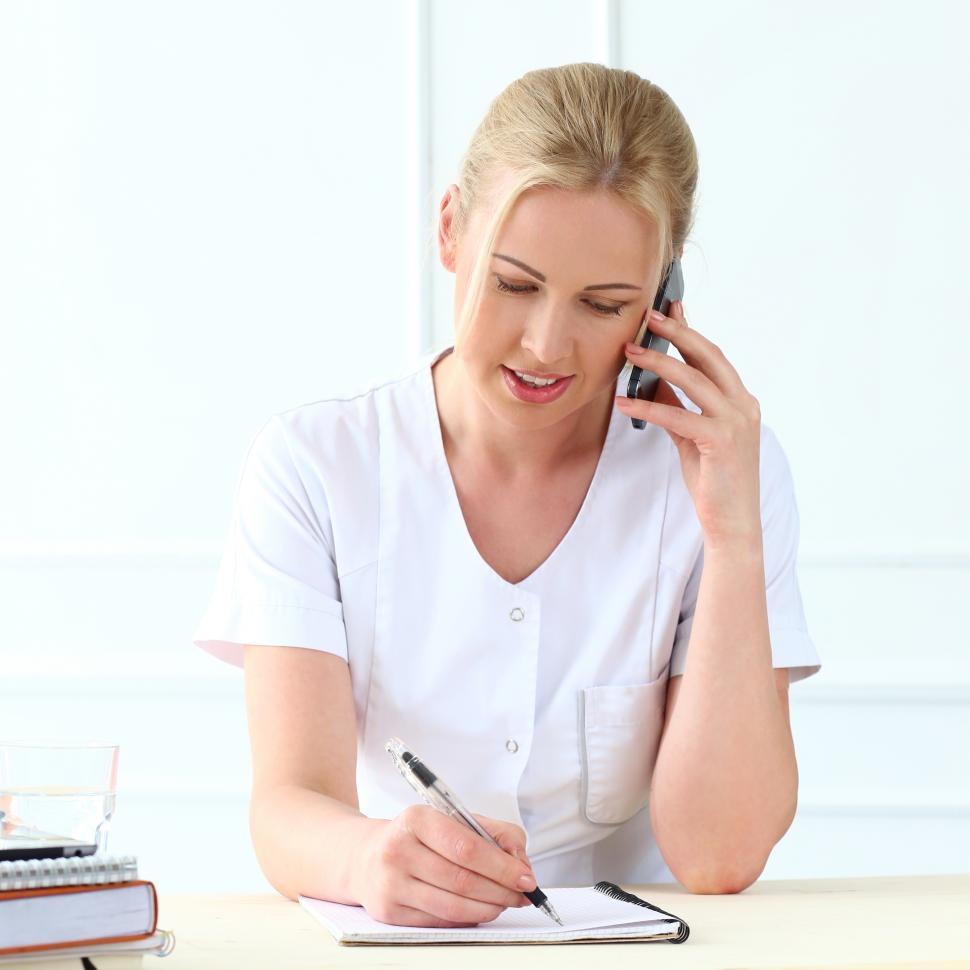 Free Image of Professional woman on the phone taking notes 