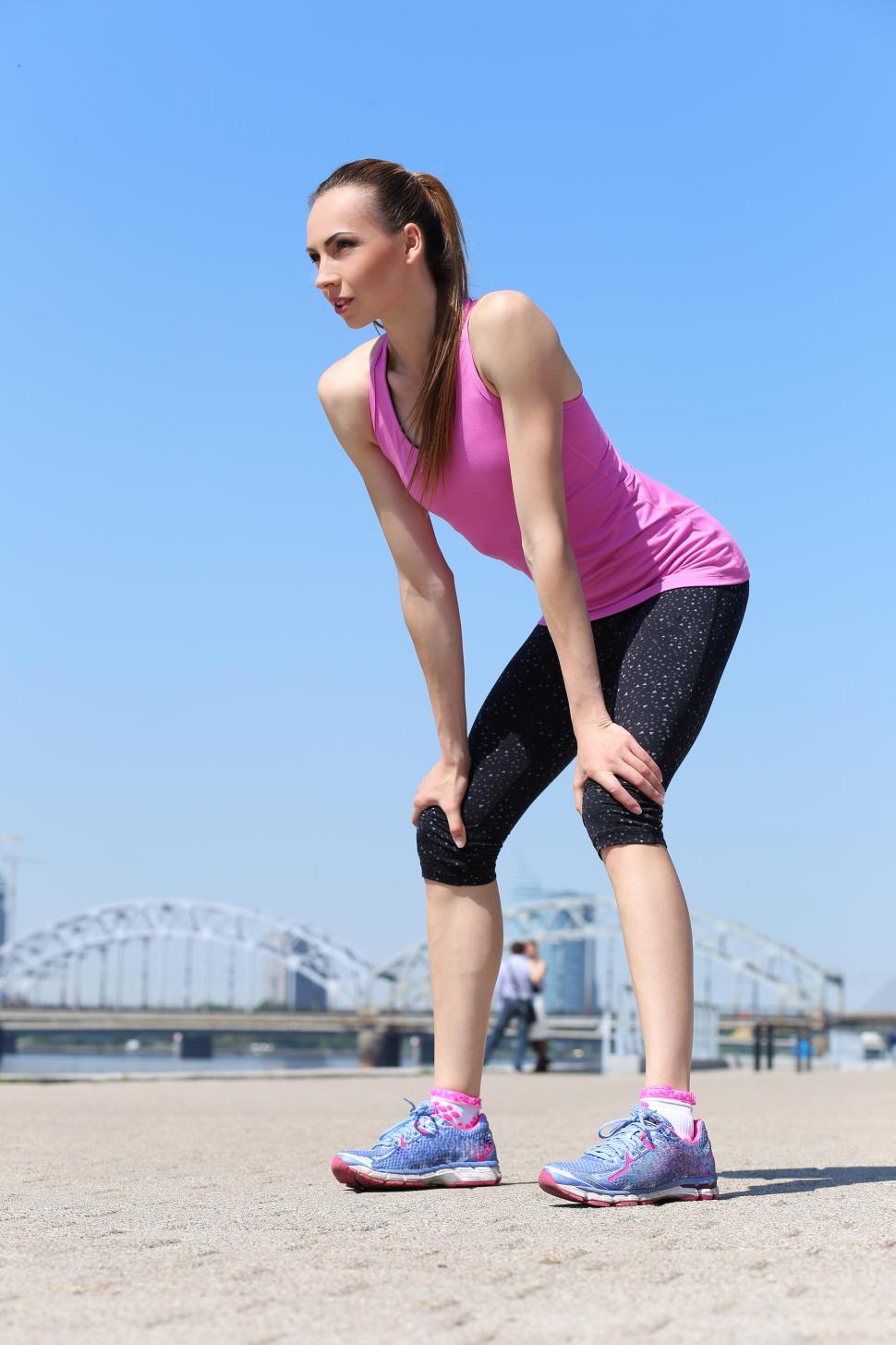 Free Image of Sport. Attractive girl with hands on knees during a run 