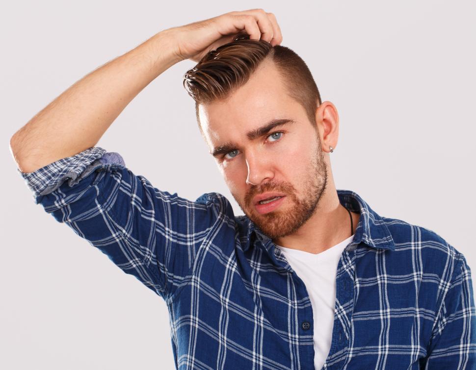 Free Image of Emotions. Young man scratching head in confusion 
