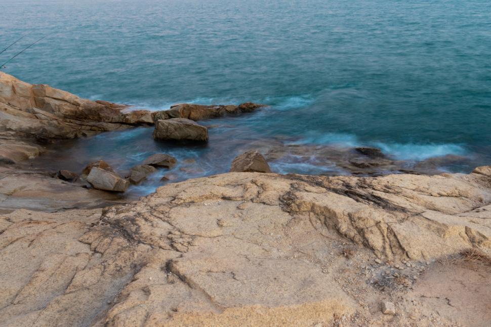 Free Image of Man Fishing on Rocks by Water 